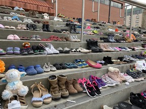 A memorial of 215 shoes, left in memory of 215 children discovered in a mass grave on the grounds at the former Kamloops Indian Residential School uncovered the remains of 215 children, outside the Jubilee Centre on Monday, May 31, 2021. Laura Beamish/Fort McMurray Today/Postmedia Network