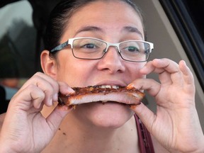 Andrea Crowder enjoys her ribs at the takeout style 2020 Tillsonburg Ribfest, organized by the Tillsonburg Thunder hockey team. This year they will be running two takeout-style ribfests, one in Woodstock June 18-20 at the Civic Centre, and of course, one in Tillsonburg Sept. 24-26 in Memorial Park. (Chris Abbott/File Photo)