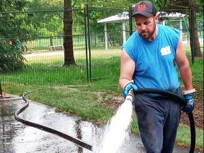 Trevor Hewitson, a water truck driver for GFS Services, Talbotville, waters new grass near the Pinafore Park splash pad that opens Tuesday. The lawn is part of a new playground that won't open for a while longer. (Eric Bunnell photo)