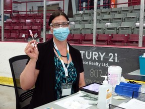 Public health nurse Tekla Rundle with the Northwestern Health Unit holds up a vaccine dose at the mass vaccination clinic at the Kenora Recreation Centre. All adults aged 18 and over in Ontario are now eligible to book COVID-19 vaccine appointments.