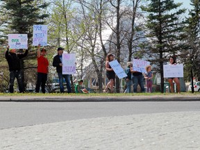 A small group of Kenora residents held signs protesting government restrictions at the roundabout in downtown Kenora amid the global COVID-19 pandemic on Saturday, May 15.