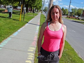 Katy James decided to draw chalk hearts on the sidewalk near her home on First Avenue West, Tuesday, as a way to honour the 215 children whose remains were found at a former residential school in British Columbia. She hopes others will add to the hearts. Michael Lee/The Nugget
