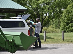 Conservation authority staff used buckets, trucks and even a front-end loader in the cleanup Wednesday of about 600 carp fish that have died in Pittock lake over the last two weeks – a combination of stress from spawning and sudden water temperature increases. (Kathleen Saylors/Woodstock Sentinel-Review)