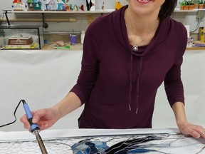 Local Stained-glass artist Chrissy McLelland adds a few finishing touches to her latest exquisite work of art.
(Supplied by Artists' Association of Beaumont)