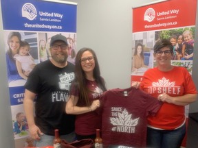 Top Shelf Canada has announced a new United Way promotion for this summer. Adina Melanson and Josh Lines shows United Way board member and CUPE 1238 president Michele LaLonge-Davey (right) some of the several t-shirt designers that are available shortly for purchase. United Way organizations in Canada will receive $5 from each clothing item sold during the 2021 summer. United Way photo