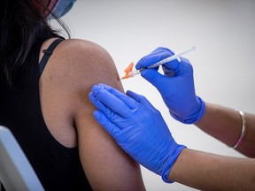 A woman receives her first dose of the Pfizer COVID-19 vaccine at an immunization clinic at the Gurdwara Dukh Nivaran Sahib, in Surrey, B.C., on Friday, May 14, 2021. PHOTO BY DARRYL DYCK /THE CANADIAN PRESS