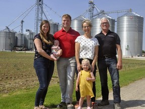 The Van Der Burgt family in front of their Mitchell grain operating business, Ellen (left), holding son Finn, Ron, daughter Lina and parents Riny and Michael. ANDY BADER/POSTMEDIA NETWORK