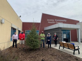 Airdrie Health Foundation Board chair Ryan Thompson (from left to right), Dave Smith from Blue Grass Nursery, Rod Toth and Nicole Glindemann from Precise Pruning, and Virginia Wheeler, site manager for the Airdrie Community Health Centre stand with the newly planted Tribute Tree outside of the Health Centre in June 2021.
