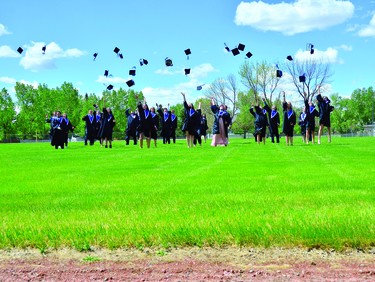County Central High School graduates throw their caps into the air May 29 at the field by the school.