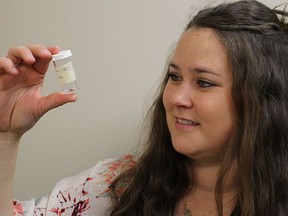 Jenna Armitage, a public health inspector in Lambton County, looks at a tick into a plastic vial in this file photo from 2019. File photo/Postmedia Network