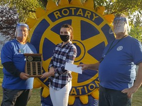 Rotarian Stew Hennig, Fort High 2020 valedictorian Karissa Goulding, and Ted Griffiths pose for a photo as Goulding accepts a scholarship from the Fort Saskatchewan Rotary Club last year. The local Club is offering two $1,000 scholarships to two local graduates again this year. Photo Supplied.