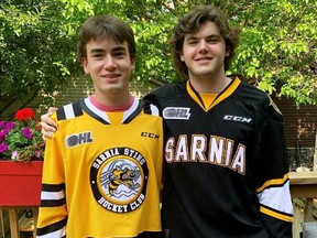 Sarnia Sting 2021 first-round draft pick Angus MacDonell, left, and his older brother, Aiden, don their new Sting jerseys. (Sarnia Sting Photo)