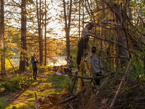 Set decorators for 'Flee The Light' hang hexing herbs and mushrooms from tree branches in preparation for the opening scene of the film. In the background, a witches' coven awaits sunset. Lizz Lott Photo
