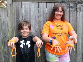 Hayley Sowinski, 12, and her brother Zach, 8, show some of the bracelets she's making to sell as a fundraiser with all the proceeds to be donated to the Indian Residential School Survivors Society. Ellwood Shreve/Postmedia Network