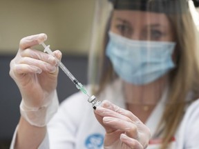 Pharmacist Alison Davison prepares a dose of Pfizer-BioNTech COVID-19 vaccine at Shoppers Drug Mart pharmacy on 17 Ave. S.W. in Calgary on Friday, March 5, 2021. Azin Ghaffari/Postmedia