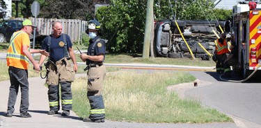 A man speaks with firefighters following a collision near Boundary Road and South Market Street on Friday, June 18, 2021. (BRIAN KELLY/THE SAULT STAR/POSTMEDIA NETWORK)