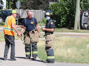 A man speaks with firefighters following a collision near Boundary Road and South Market Street on Friday, June 18, 2021. (BRIAN KELLY/THE SAULT STAR/POSTMEDIA NETWORK)