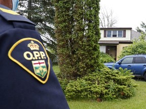 Prince Edward County OPP Sgt. Sean Guscott stands outside a home east of Rossmore Friday afternoon. Police said they took Manitoba homicide suspect Eric Wildman, 34, and another person into custody earlier in the day after taking gunfire while conducting a search warrant at the home Thursday night.