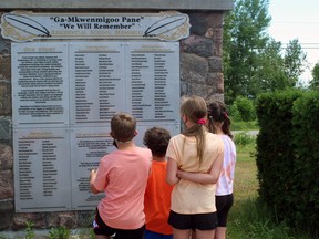 Four of the young participants in the Every Child Matters Bike Ride look at the names on the Residential School Memorial in Duchesnay on Nipissing First Nation, Saturday. PJ Wilson/The Nugget