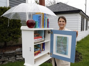 Belleville's Nicole Black opens the door to the little library she and partner Cory Anderson created. It includes a map to guide people to local "treasures," including trails and pop-up businesses.
