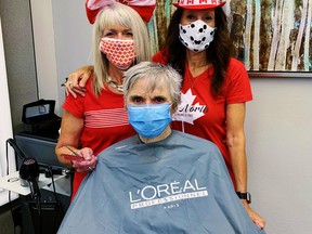 The Canada Day party started early at the Blade Salon in Port Dover Wednesday now that the latest province-wide pandemic lockdown on stylists and beauticians has been lifted. In back, from left, are Blade stylists Tammy Hutchinson and Eddie Alaimo. In the chair is client Joyce Seely. – Monte Sonnenberg