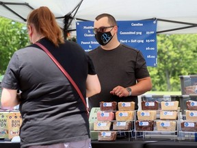 Kylle Benoit of B's Sweets serves a customer during the Chatham Armoury Outdoor Spring Market in Chatham, Ont., on Saturday, June 5, 2021. (Mark Malone/Chatham Daily News)