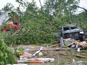 The Zehrs van, which was parked beside the house, when the reported tornado hit, sits destroyed under a tree on Saturday.