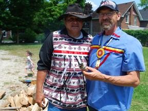 Ken Albert, left, and Paul Nadjiwan tended to the sacred fire Friday during a ceremony at the M'Wikwedong Indigenous Friendship Centre in Owen Sound to honour the 215 children whose remains were found buried at the former Kamloops residential school last month. DENIS LANGLOIS