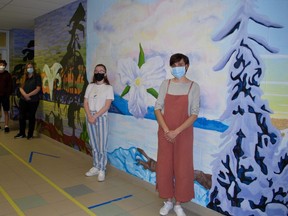 École secondaire Catholique Saint-Dominique-Savio students (from left to right) Spencer Stobbe, Emily Matheson and Elania Gunn stand with art teacher Éloïse Guindon, right, in front of the mural they created in the school's senior wing. DENIS LANGLOIS