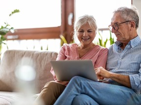 Mature couple using a laptop while relaxing at home
