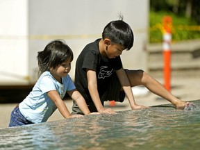 Ezekiel David (7, right) cools his heels with his sister Eliyanah (3) at the pool in front of the Alberta Legislature in Edmonton. Temperatures in Grande Prairie this week could see the mercury rise above 40 Celsius on Tuesday.