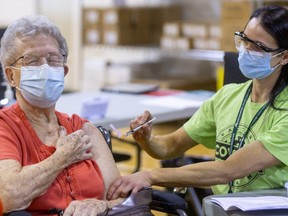 Shirley Banks, 88, flinches she sets aside her fear of needles to get a COVID-19 vaccine shot from public health nurse Stephanie McKee at the North London Optimist community centre on Cheapside Street. Photograph taken on Wednesday March 17, 2021. (Mike Hensen/The London Free Press)