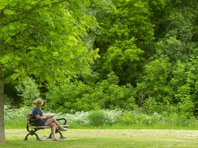 Angela Leslie enjoys a quiet read under a tree in Gibbons Park in London. Moments of solitary bliss can be one of the effects of COVID isolation. Photograph taken on Friday June 4, 2021. Mike Hensen/The London Free Press