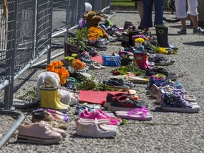 Shoes are placed at the front entrance of Queen's Park in Toronto, Ont. on Monday May 31, 2021 following the discovery of the remains of 215 children found buried on the site of a former residential school in Kamloops, B.C.