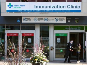 A security guard checks in a customer at the downtown Calgary COVID-19 vaccination clinic.The province’s 71.3 per cent first-dose vaccination rate of people over the age of 12 is bolstered by larger population centres, show data provided by Alberta Health. Calgary has one of the highest rates with approximately 76.5 per cent of eligible people being at least partially immunized by late last week, while Edmonton is hovering at 73.5 per cent.