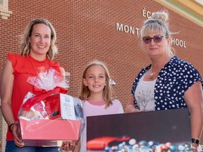 Ivy Calder, a Grade 4 student at Ecole Montrose (centre) is presented with a print of her award-winning photo "Losing my Marbles" by Tanya Sedore (second from right) and Trena Shaw also of Tanya Sedore photography. The photo was the winning entry in the 12 and under category.