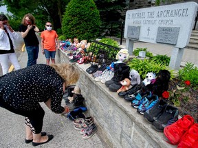 Kara Hertendy lays items on the steps of the Church of St. Michael the Archangel June 13 in Belleville. Sheri Clark, background left, and Lynn Olsen, background right, also participated.