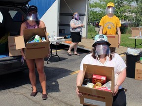 Tori Redding (left), Kaitlyn Braun and Jared Carrol unload boxes of items gathered on Saturday during the third annual OneChurch Food Drive in Brantford.