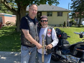 David Boone (left) of Paris, Ontario passes the title of Grand Commander, North America chapter of Templars Against Child Abuse to a man known only by his nickname Turtle. The organization aims to create a safer environment for abused children.
