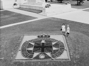The Brantford Parks Board planted a floral replica of the Imperial Order Daughters of the Empire insignia in parkland beside the Brant War Memorial to celebrate the golden anniversary of the IODE's Municipal chapter in 1969.  Looking on are vice-regent Mrs. Marc Lefebvre (left) and Mrs. James Clarke.