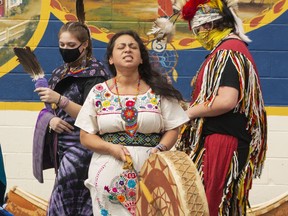 Yessica Rivera Belsham sings Tonantzin, a song in the Nahuatl language, while family members dance around her in traditional clothing during the Indigenous Peoples Day event on Monday.  By