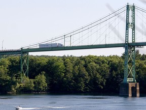 A transport truck crosses over the Thousand Islands Bridge from United States, back into Ontario as a boat passes by underneath on June 23, 2021.