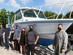 Staff at CSN Collision Centre in Tilbury, shown June 9, 2021, show off their work on a research vessel used by a University of Windsor research team.