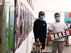 Cory Cowan, right, and his son Avery, 17, showcase some decks in the back room of their new business, Family Skateboard Company, in downtown Chatham June 23, 2021.