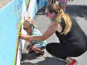 Diversity Cornwall president Elizabeth Quenneville and her son Ryder Ragavold were the first to put their handprint on a the newly unveiled mural in Lamoureux Park, on Wednesday June 30, 2021 in Cornwall, Ont. Francis Racine/Cornwall Standard-Freeholder/Postmedia Network