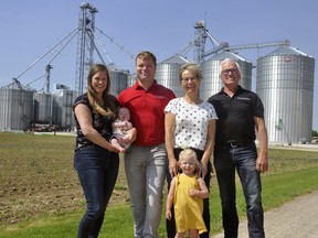 The Van Der Burgt family in front of their Mitchell grain operating business, Ellen (left), holding son Finn, Ron, daughter Lina and parents Riny and Michael. ANDY BADER/MITCHELL ADVOCATE