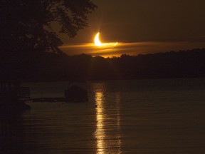 The sun rises over Bob's Lake partially eclipsed by the moon during an annular eclipse near Parham, Ont. on Thursday, June 10, 2021. 
Elliot Ferguson/The Whig-Standard/Postmedia Network
