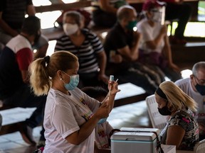 A health worker prepares a dose of the Cuban vaccine candidate Abdala against COVID-19, during a mass vaccination campaign at the Andres Blanco complex of Fuerte Tiuna in Caracas, Venezuela, on June 30, 2021. The Venezuelan government announced on June 24, 2021, it agreed with Cuba to purchase 12 million doses of the Abdala vaccine, which according to the laboratory that developed it has an effectiveness of 92 per cent and waits for the approval of the WHO. (Yuri Cortez/Getty Images)