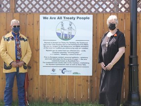 Brent Digness, representing the Metis Nation of Saskatchewan stands with Mayor Rennie Harper in front a sign at Nipawin Town Square. Photo Susan McNeil.