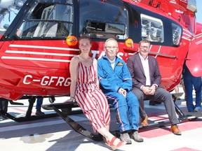 Jessi Fredin, former patient and current paramedic, Rod Gantefoer and Premier Scott Moe sit with a new STARS helicopter named after Gantefoer, who is credited with bringing the organization to Saskatchewan. Photo Susan McNeil.